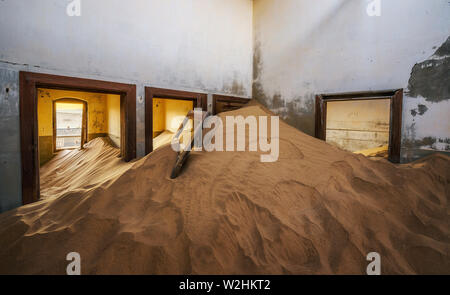 Le rovine di una casa riempita di sabbia nella cittadina mineraria Kolmanskop, Namibia Foto Stock