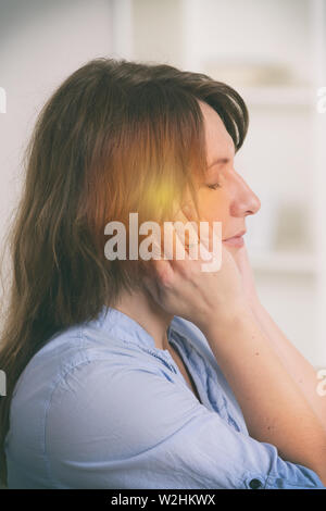 Donna pratica self Reiki con trasferimento di energia attraverso le palme, una sorta di medicina energetica. Foto Stock