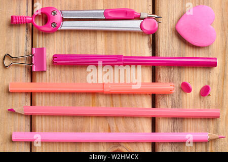 Oggetti di cancelleria rosa su sfondo di legno Foto stock - Alamy