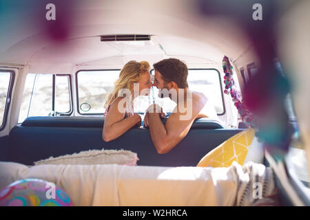 Coppia romantica seduti in un camper presso la spiaggia Foto Stock