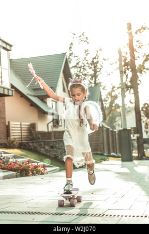 Active grave giovane ragazza di stare su uno skateboard Foto Stock