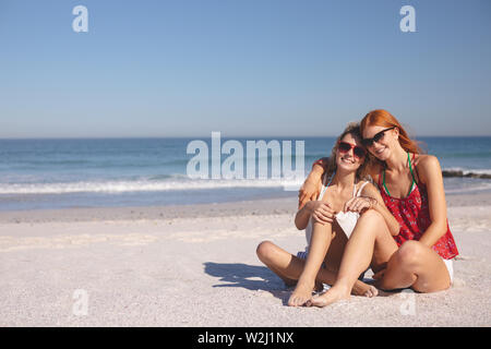 Amici di sesso femminile insieme rilassante sulla spiaggia Foto Stock