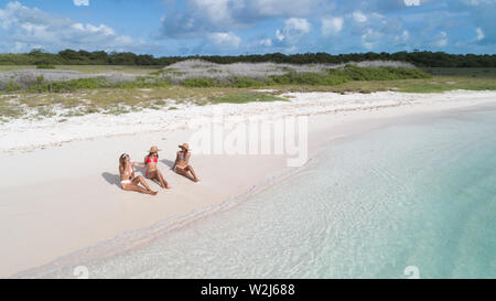 Tre donna seduta sulla spiaggia vista aerea Foto Stock