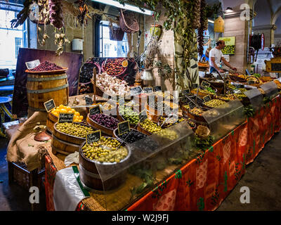 Il cibo al coperto bancarella vendendo olive a Autun Mercato del venerdì in Autun, Borgogna, in Francia il 5 Luglio 2019 Foto Stock