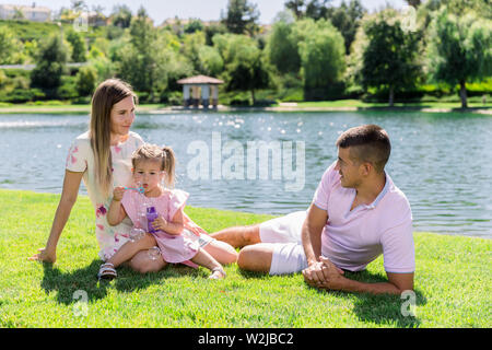 La famiglia felice al parco avente un buon tempo insieme Foto Stock