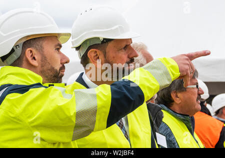 09 luglio 2019, Bassa Sassonia, Burgdorf: Olaf giace (SPD, M), il Ministro per l'ambiente, energia, la costruzione e la protezione del clima nella Bassa Sassonia, e Tim Meyerjürgens (l), operativo amministratore delegato dell'operatore di rete Tennet, stanno parlando su un sito in costruzione durante un test di un aratro multiplo per la posa di tre-fase i cavi di messa a terra. Tennet prove il primo aratro multipli per la posa di 380 kV trifase di cavi di messa a terra. Foto: Cindy Riechau/dpa Foto Stock