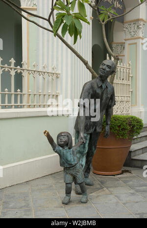 Singapore, Singapore - febbraio 09, 2017: statue in bronzo di un uomo anziano e una giovane ragazza di fronte al Museo Peranakan sulla strada armena Foto Stock