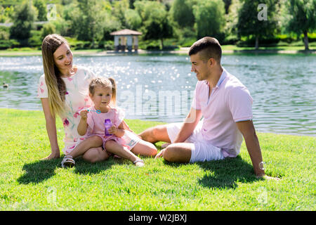 La famiglia felice al parco avente un buon tempo insieme Foto Stock