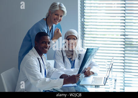 Happy team medico seduti su una sedia in ospedale Foto Stock