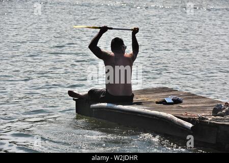 2 Gli uomini paddling recuperati dock torna alla loro casa sul lago in una giornata calda a Clearlake Clear Lake California al salvataggio per la pesca e di vincolare il battello Foto Stock