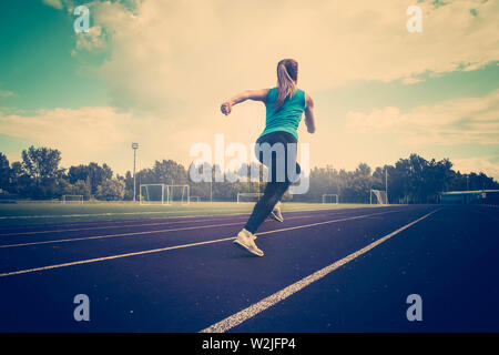 Giovane donna fitness runner in esecuzione su via Foto Stock