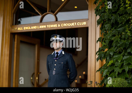 Un membro delle forze armate guardie un ingresso al centre court il giorno otto dei campionati di Wimbledon al All England Lawn Tennis e Croquet Club, Wimbledon. Foto Stock