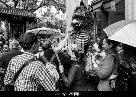 I turisti cinesi Rub la statua del drago per buona fortuna all'entrata di Wong Tai Sin Temple, Hong Kong, Cina Foto Stock