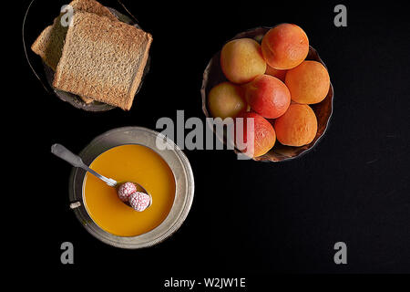 La marmellata di albicocche. Fresche albicocche una tazza di tè nero e qualche toast spalmato con la marmellata. Foto Stock