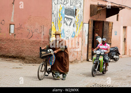 Lavoratore locale in bicicletta Passeggiate attraverso la città vecchia Medina strade di Marrakech Foto Stock