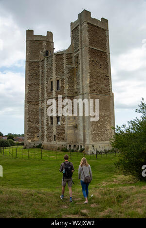 Giovane a piedi verso il castello di Orford, Suffolk, Inghilterra Foto Stock