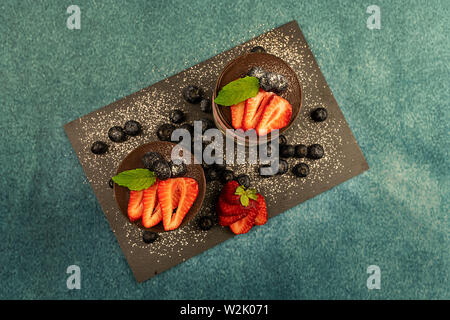 Mousse di biscotto, ciliegie, ananas e ricoperte di cioccolato ricoperto con una crema di cioccolato, mirtilli e fragole. Foto Stock