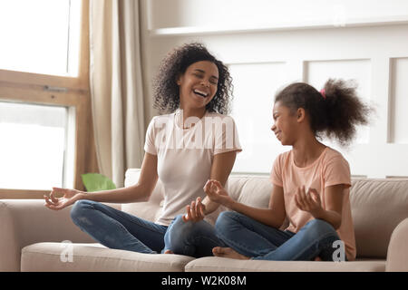 Una sana felice madre africana nell'insegnamento dello yoga capretto felice figlia ridere Foto Stock