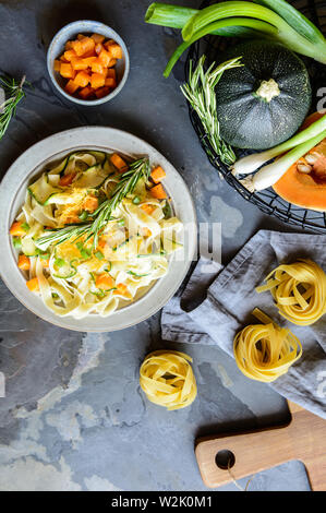 Burro vegetariana squash insalata di pasta con zucchine a fette, lo scalogno e conditi con formaggio Cheddar grattugiato Foto Stock