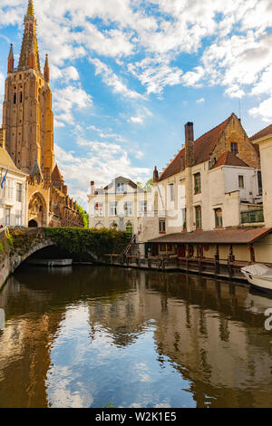 Vista del Dijver canal con canal boat, vite ponte coperto, edifici tradizionali e la Cattedrale di Notre Dame a Bruges, Belgio Foto Stock