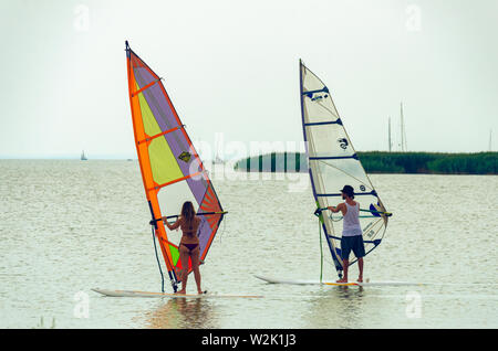 Podersdorf am See, Austria - 15 agosto 2015: due windsurf sul lago Neusiedler See in nuvoloso giorno di estate Foto Stock