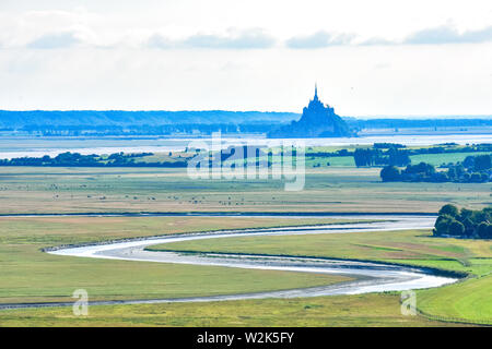 Rio si fa strada tra i campi e campi coltivati fino a Mont Saint Michel, Francia Foto Stock