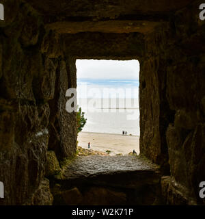 Guardando il mare e il blu del cielo attraverso una finestra di pietra. Sensazione di speranza. Foto Stock