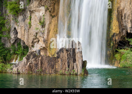 Crystal Clear, acqua pura e correre verso il basso le rocce di muschio in un bellissimo colore azzurro lago presso il Parco Nazionale dei Laghi di Plitvice in Croazia Foto Stock