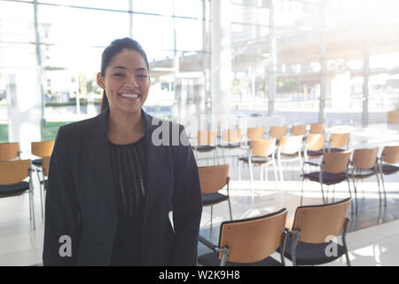 Imprenditrice sorridente in piedi in sala conferenze Foto Stock