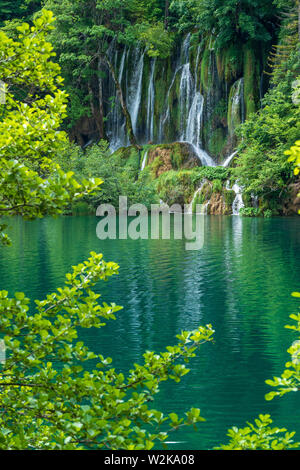 Crystal Clear, acqua pura e correre verso il basso le rocce di muschio in un bellissimo colore azzurro lago presso il Parco Nazionale dei Laghi di Plitvice, Plitvička Jezera, Croazia Foto Stock