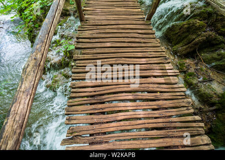 Un passaggio sopraelevato fatto di assi di legno che conduce attraverso il Parco Nazionale dei Laghi di Plitvice, Croazia Foto Stock