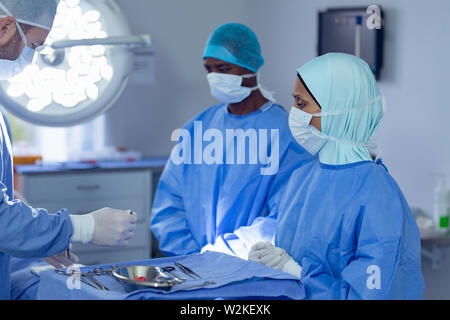 I chirurghi di eseguire un intervento chirurgico in camera operativa Foto Stock