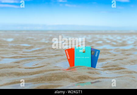 Monzo, Starling, Revolut carte bancarie sulla spiaggia. Concetto per i migliori viaggi e vacanze banca virtuale carte. Foto Stock