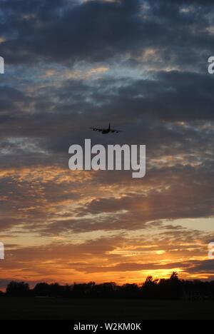 tramonto sequenza oro bagliore con un sacco di nuvole con silhouette di alberi Foto Stock