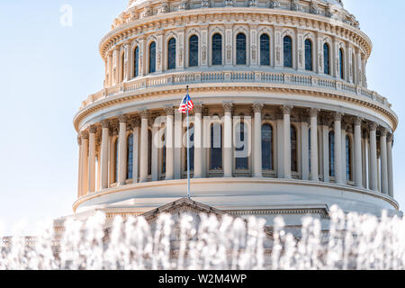 Il Congresso Usa dome con sfondo di fontana acqua bandiera americana sventolare a Washington DC, Stati Uniti d'America sul capitale Capitol Hill e colonne Foto Stock