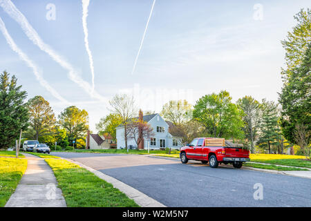 Herndon, Stati Uniti d'America - 23 Aprile 2019: Northern Virginia Fairfax County quartiere residenziale in primavera con le case e le vetture stradali parcheggiata da prato e sidewa Foto Stock