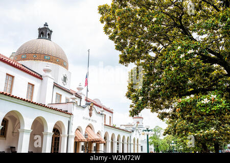 Hot Springs, Stati Uniti d'America - 4 Giugno 2019: Storico Quapaw Terme Spa bath house con bandiera americana e la cupola da molti magnolia alberi meridionale in città Foto Stock