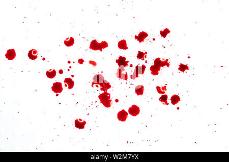 Il gocciolamento rosso sangue splash, l' orrore e la nozione di emergenza, isolato su sfondo bianco. Con tante gocce di sangue rosso sul pavimento bianco Foto Stock