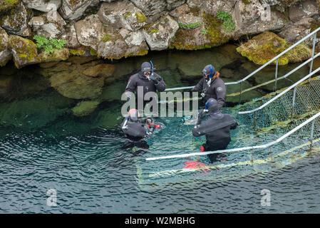 SILFRA, Islanda - 20 Maggio 2019: i subacquei e gli amanti dello snorkelling preparazione di entrare in acqua a Silfra rift, il luogo dove Eurasian e l'Americano Foto Stock