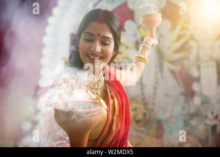 Bengali le donne sposate eseguendo dhunuchi ballo in occasione di durga puja Foto Stock