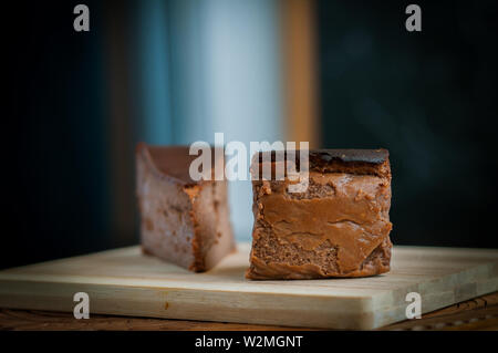 Cioccolato bruciato la cheesecake su legno bruno sfondo. il fuoco selettivo Foto Stock