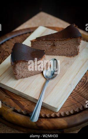 Cioccolato bruciato la cheesecake su legno bruno sfondo. il fuoco selettivo Foto Stock