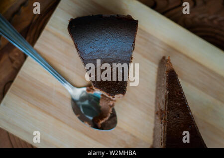 Cioccolato bruciato la cheesecake su legno bruno sfondo. il fuoco selettivo Foto Stock