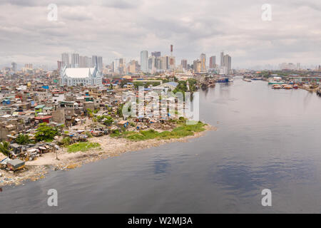 Il paesaggio urbano di Manila, con baraccopoli e grattacieli. Porto di mare e le zone residenziali. Il contrasto dei poveri e ricchi di aree. La capitale delle Filippine, vista da sopra. Foto Stock