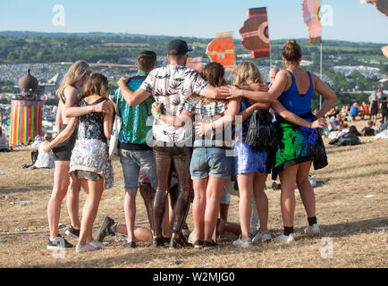 I frequentatori del festival posano per una foto sopra il parco e la torre a nastro a Glastonbury 2019 Foto Stock