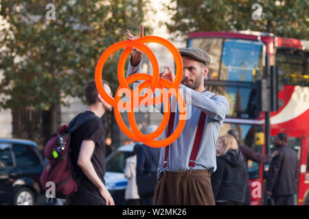 London, Regno Unito - 12 Ottobre 2009 - artista di strada eseguire con anelli di giocoleria in Trafalgar Square Foto Stock