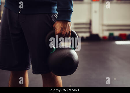 Immagine ravvicinata di uomo con kettlebell in palestra Foto Stock