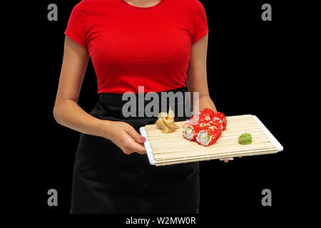 Close-up di mani di uno chef professionale rendendo il sushi e le bobine in cucina del ristorante. Giapponese cucina tradizionale. Il processo di cottura. Le mani Foto Stock