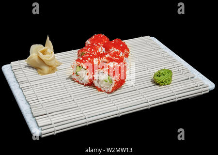 Close-up di sushi e panini al ristorante Cucina. Giapponese cucina tradizionale. California sushi rotoli sul supporto di bambù isolato su nero Foto Stock