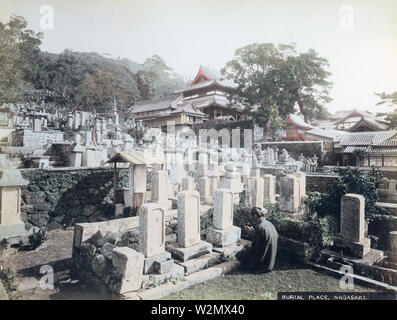 [ 1890 GIAPPONE - Preghiera al Cimitero buddista, Nagasaki ] - un uomo prega davanti a una tomba nel cimitero di Honrenji tempio in Chikugo-machi, di Nagasaki. Honrenji fu distrutta dalla bomba atomica nel 1945 (Showa 20), ma è stata gradualmente ricostruita. Xix secolo albume vintage fotografia. Foto Stock